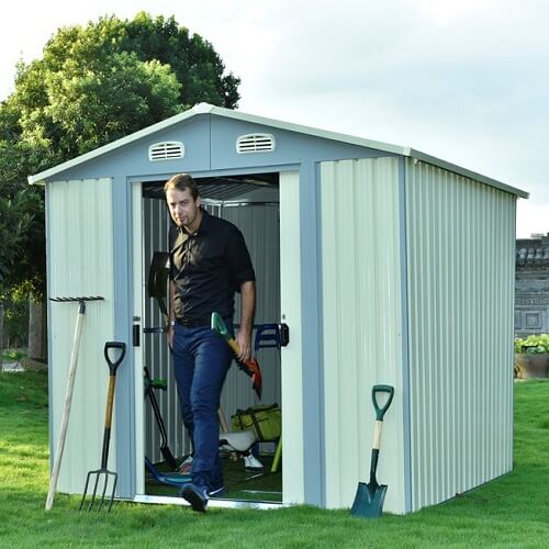 A man walking out of the door from a garden shed