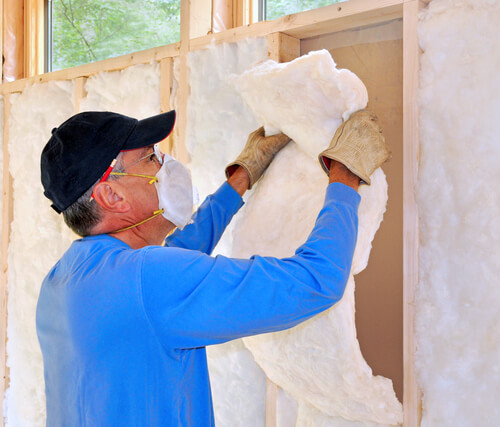Man installing fiberglass insulation