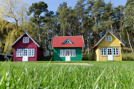 three multi-colored small tiny house on the lawn in the forest